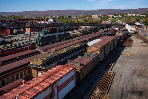 Vintage train cars and locomotives, covered in rust and are in disrepair, rest on tracks in Scranton, PA, USA.