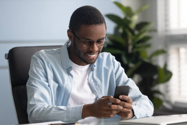 istock Smiling african american employee using mobile applications. 1182227855