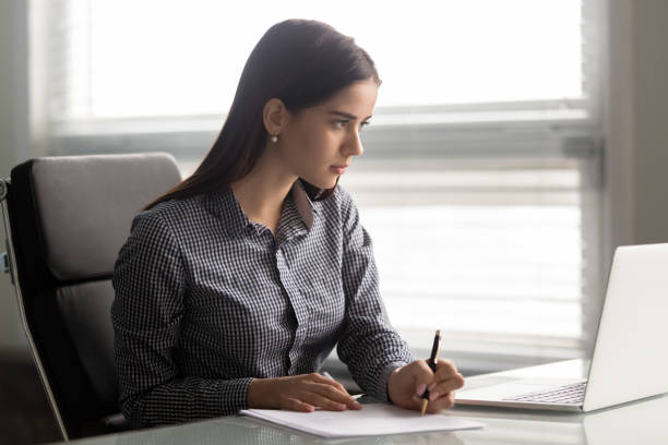 istock Focused young confident businesswoman working with paper documents. 1182227873