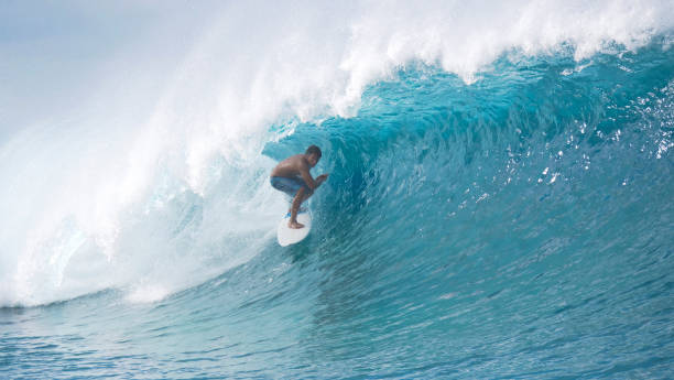 istock Extreme surfer drags his hand through the refreshing water while riding a wave. 1182230398