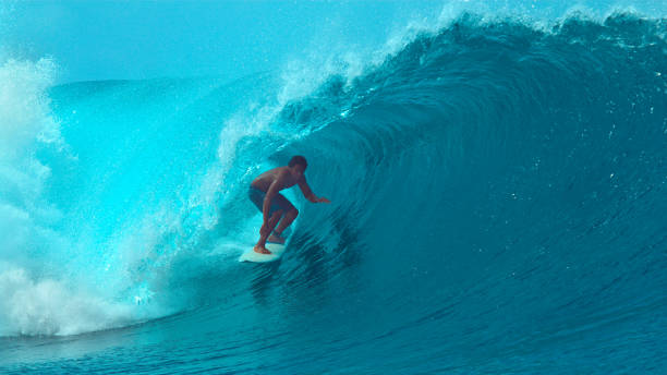 istock CLOSE UP: Wild emerald water splashes over surfer's head riding a barrel wave 1182230430