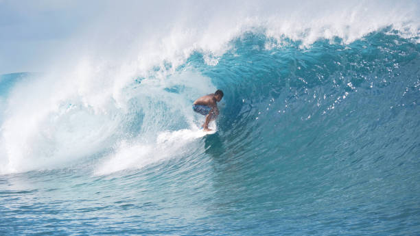 istock Wild ocean wave curls over the pro surfboarder enjoying the summer holiday. 1182230507