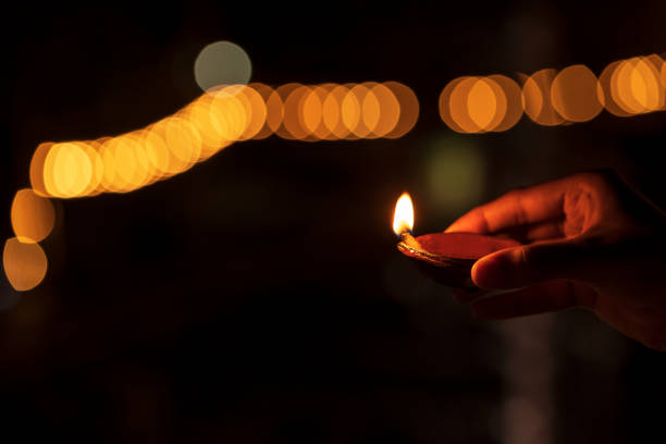 istock Diwali Man Holding Diya With Bokeh Background 1182231889