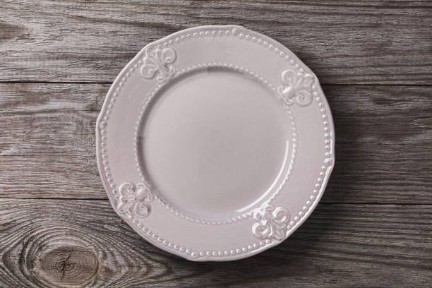 istock Empty vintage plate on a wooden table, top view. Pattern for background with food 1182234770