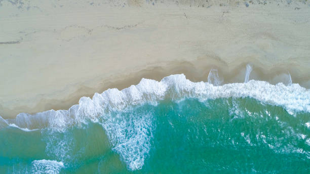 istock COPY SPACE: Flying above turquoise ocean waves washing the empty sandy beach. 1182236778