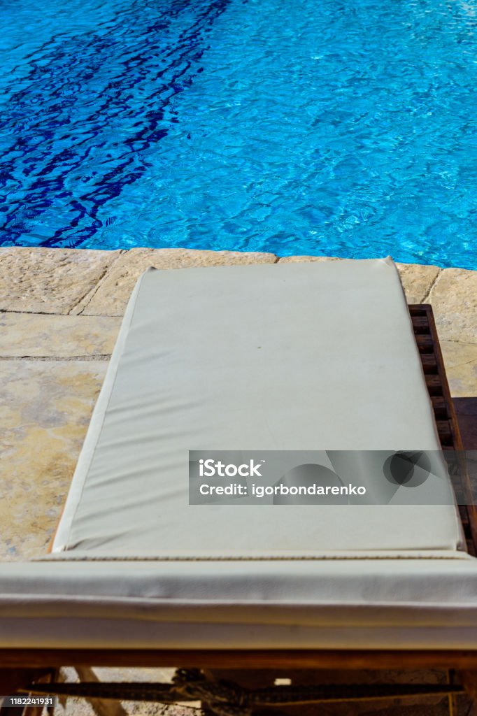 Șezlong lângă piscină cu apă limpede - Fotografie de stoc Albastru fără redevențe Șezlong lângă piscină cu apă limpede - Fotografie de stoc Albastru fără redevențe