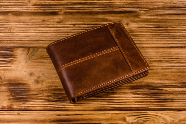istock Closed brown leather wallet on wooden table 1182241987