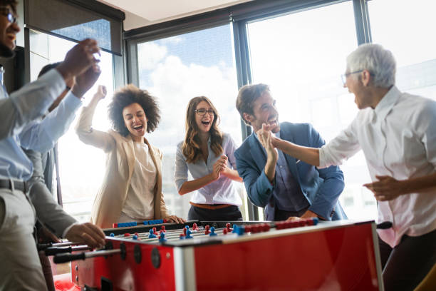 istock Employees playing table soccer indoor game in the office during break time 1182242554