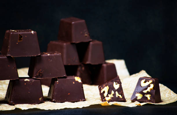 istock homemade chocolates with nuts on a black backgound - food concepts 1182243524