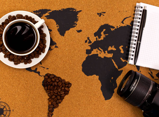 istock Coffee cup, camera and note on a map with South America made of coffee beans 1182244317
