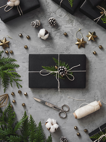 Christmas presents wrapped in black paper and elegantly decorated
