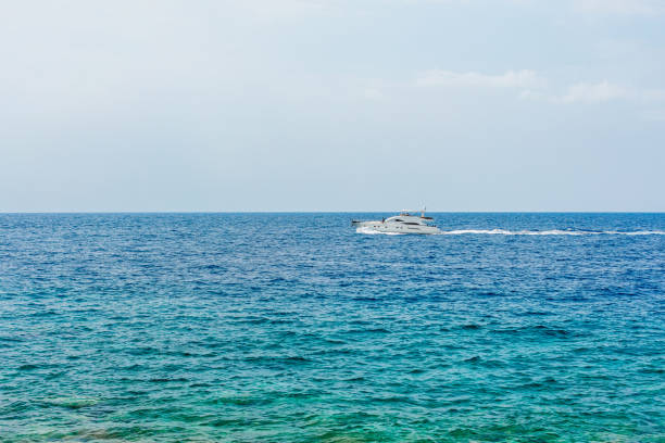 istock Boat with tourists on blue sea surface 1182245052