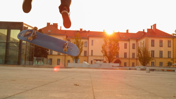 primo: lo skateboard blu si capovolge sotto i piedi di un giovane irriconoscibile. - fakie foto e immagini stock