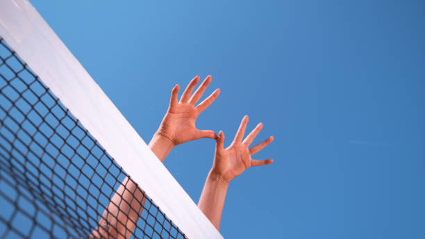 istock CLOSE UP: Unrecognizable athletic woman's hands stretch over the volleyball net. 1182247574