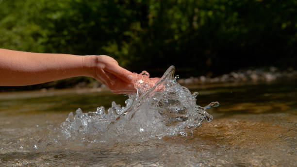 istock CLOSE UP: Unrecognizable woman scoops up a handful of refreshing river water 1182247941