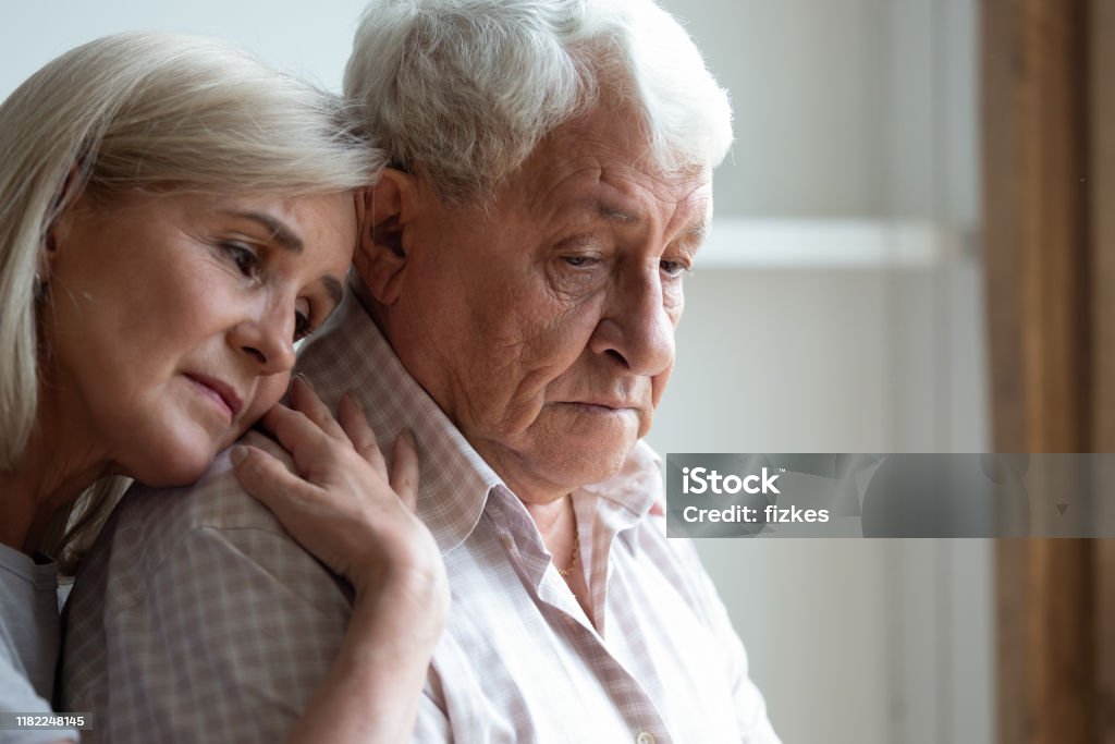 Middle-aged daughter snuggle to elderly father sharing his sorrows Senior spouses remember sad moments of life together, middle-aged adult daughter snuggle up to elderly father sharing his sorrows and heartache, embrace as symbol of empathy and compassion concept Dementia Stock Photo