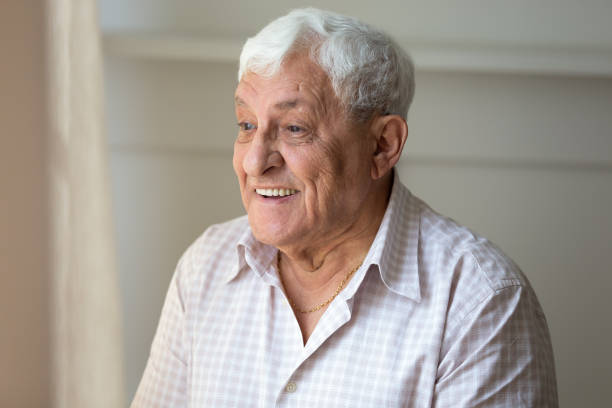 istock Elderly man looking out the window enjoy sunny day 1182248152