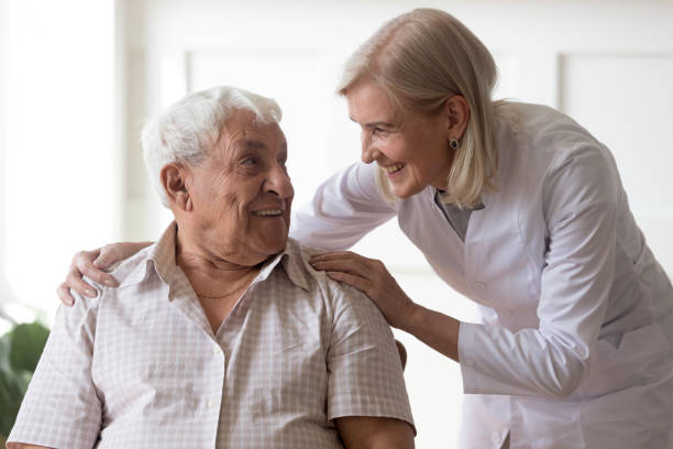 istock Senior man clinic patient interacting with nurse in white coat 1182248162