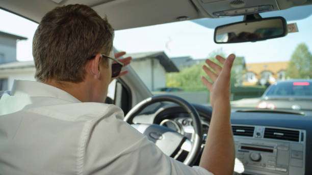 primo piano: frustrato uomo caucasico grida al traffico lento di fronte a lui. - furious road rage driver road foto e immagini stock