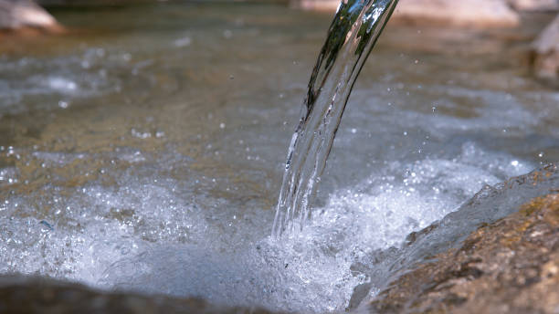 istock CLOSE UP: Glassy river water flowing over the rocky riverbed on a sunny day. 1182249960