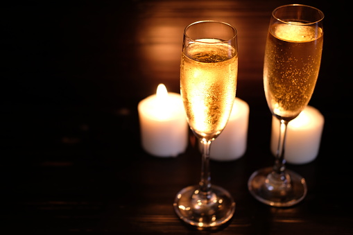 Two glass of champagne on wooden background and space for text