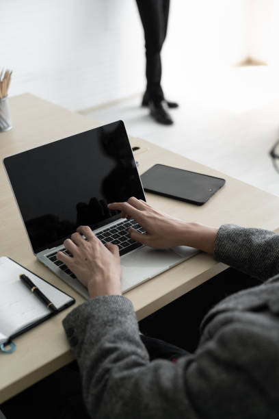 istock The businessman while typing an information on laptop with office accesssories setting on wood table. /Business and technology concept / copyspace 1182252257