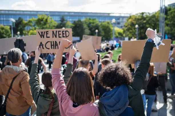 Photo of Rear view of people with placards and posters on global strike for climate change.