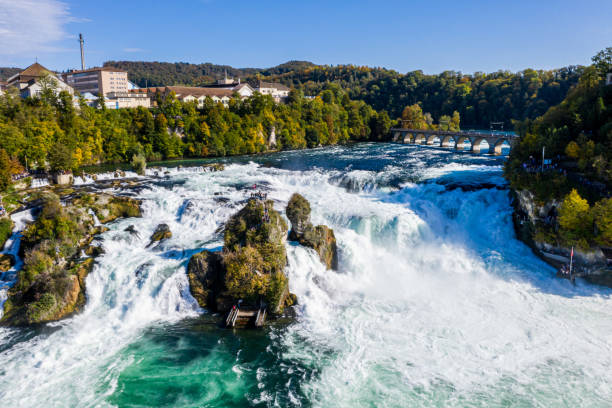 chutes du rhin, rheinfall, vue panoramique suisse. bateau de touriste dans la chute d'eau. pont et frontière entre les cantons schaffhausen et zurich. château de schloss laufen de falaise, laufen-uhwiesen - rhine falls photos et images de collection