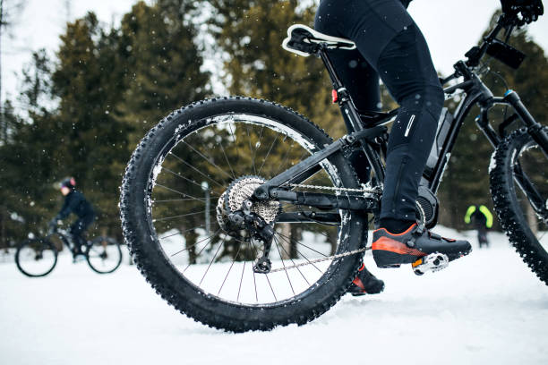 istock Midsection of mountain biker riding in snow outdoors in winter. 1182254949