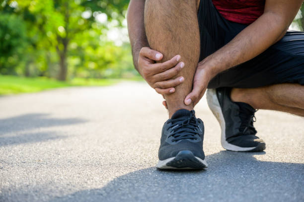 istock Broken twisted ankle. Runner touching foot in pain due to sprained ankle 1182258491