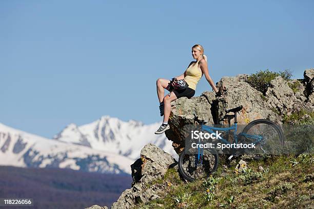 Красивая Блондинка Женщина Сидящая На Скале В Горы — стоковые фотографии и другие картинки Кататься на велосипеде