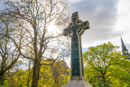 Celtic Cross in park lit by sun.