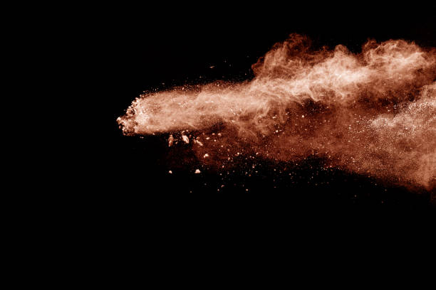 istock Brown dust explosion cloud.Brown particles splatter on black background. 1182269212