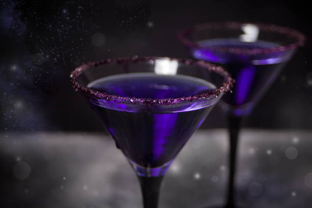 dois vidros com cocktail roxo para o partido de halloween no fundo escuro - zombie cocktail - fotografias e filmes do acervo