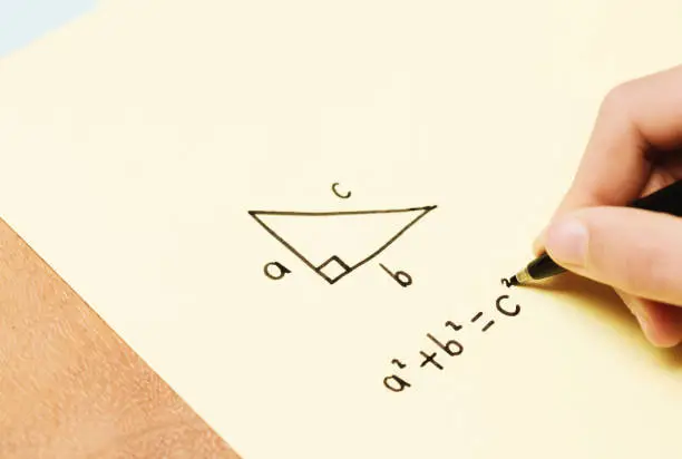 Little girl doing mathematics on a piece of paper.