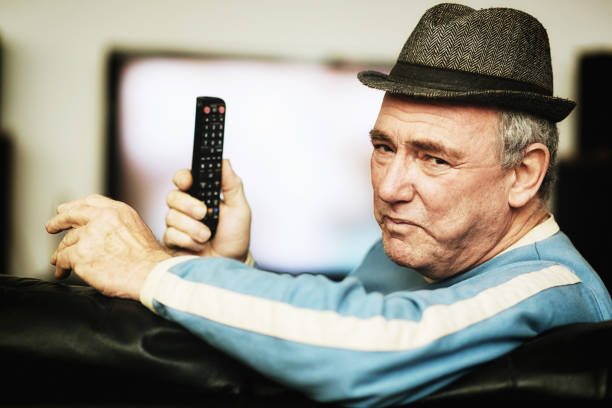 istock Angry old man holds TV remote control 1182271860