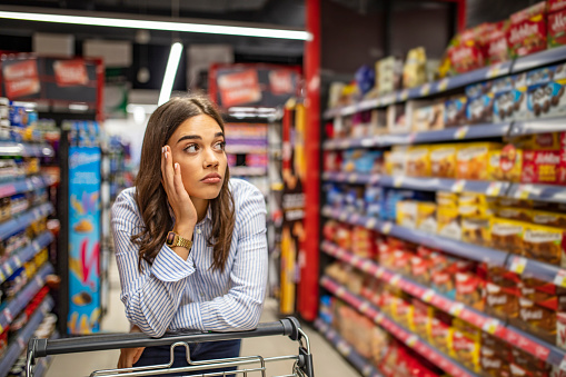 Upset woman in a supermarket looking