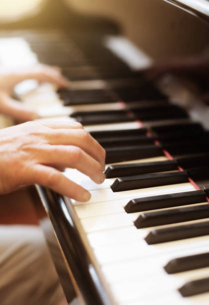 istock Musician's hands playing a magnficent grand piano keyboard 1182273476