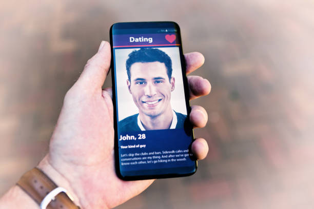 istock Gay man's hand holds a phone displaying another man on an internet dating site 1182274564