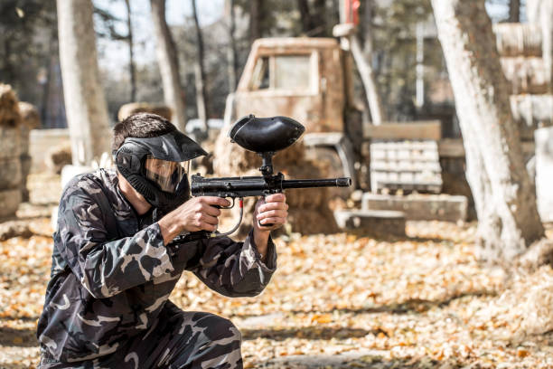 un homme avec un pistolet jouant au paintball. - gun rounds photos et images de collection