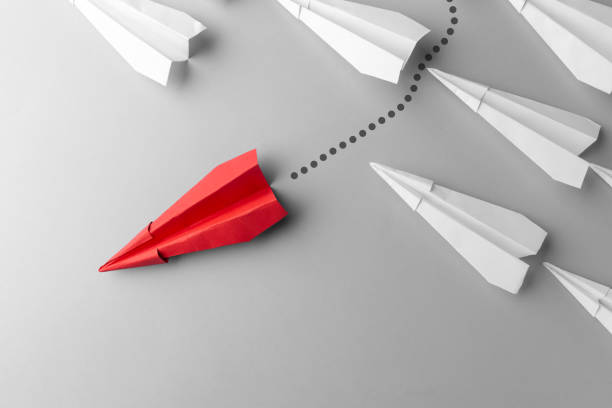 istock Red paper plane as a leader. White planes follow him. White background. 1182282757