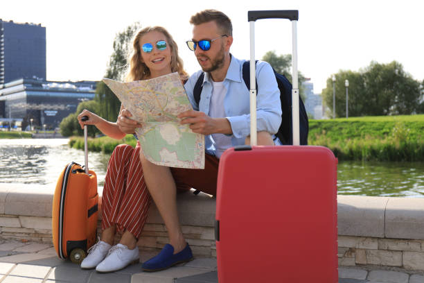 istock Lovely couple on vacation are looking at map for direction 1182286717