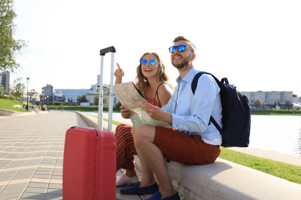 istock Lovely couple on vacation are looking at map for direction 1182286737