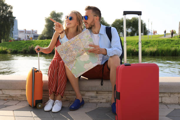 istock Lovely couple on vacation are looking at map for direction 1182288555