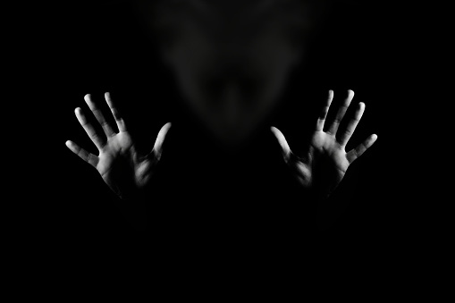 Horror background. Gesture stop. Black and white studio shot.