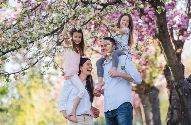 istock Young parents with small daugthers standing outside in spring nature. 1182290775