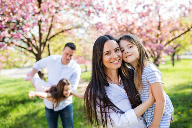 istock Young parents with small daugthers standing outside in spring nature. 1182290861
