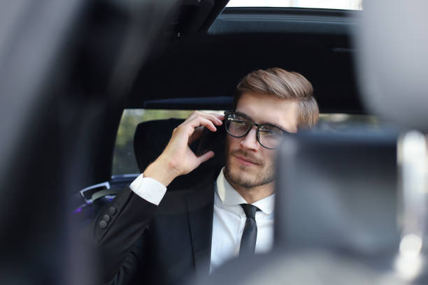 istock Thoughtful confident businessman talking on the phone while sitting in the car. 1182291407