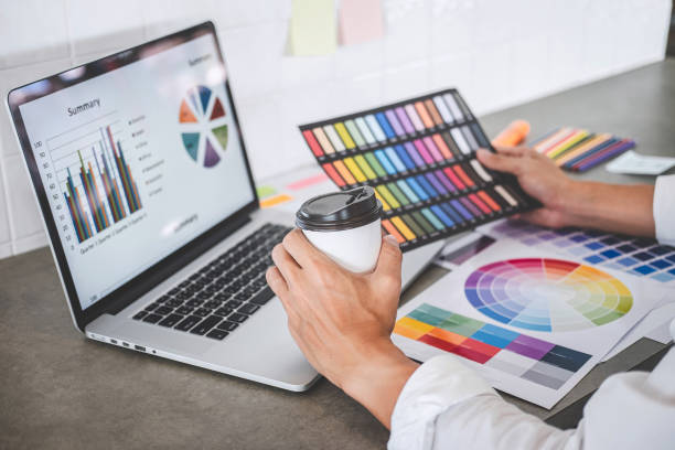 istock Young creative graphic designer working on project architectural drawing and color swatches, selection coloring on graphic chart with work tools and equipment 1182297633