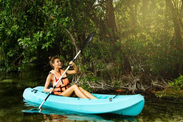 Photo of Happy young woman kayaking on the lake